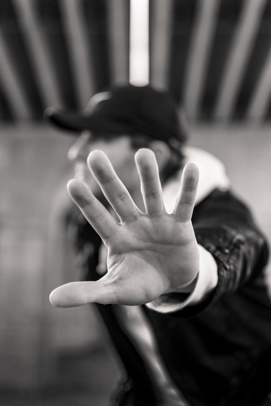 monochrome photo of man showing his left hand