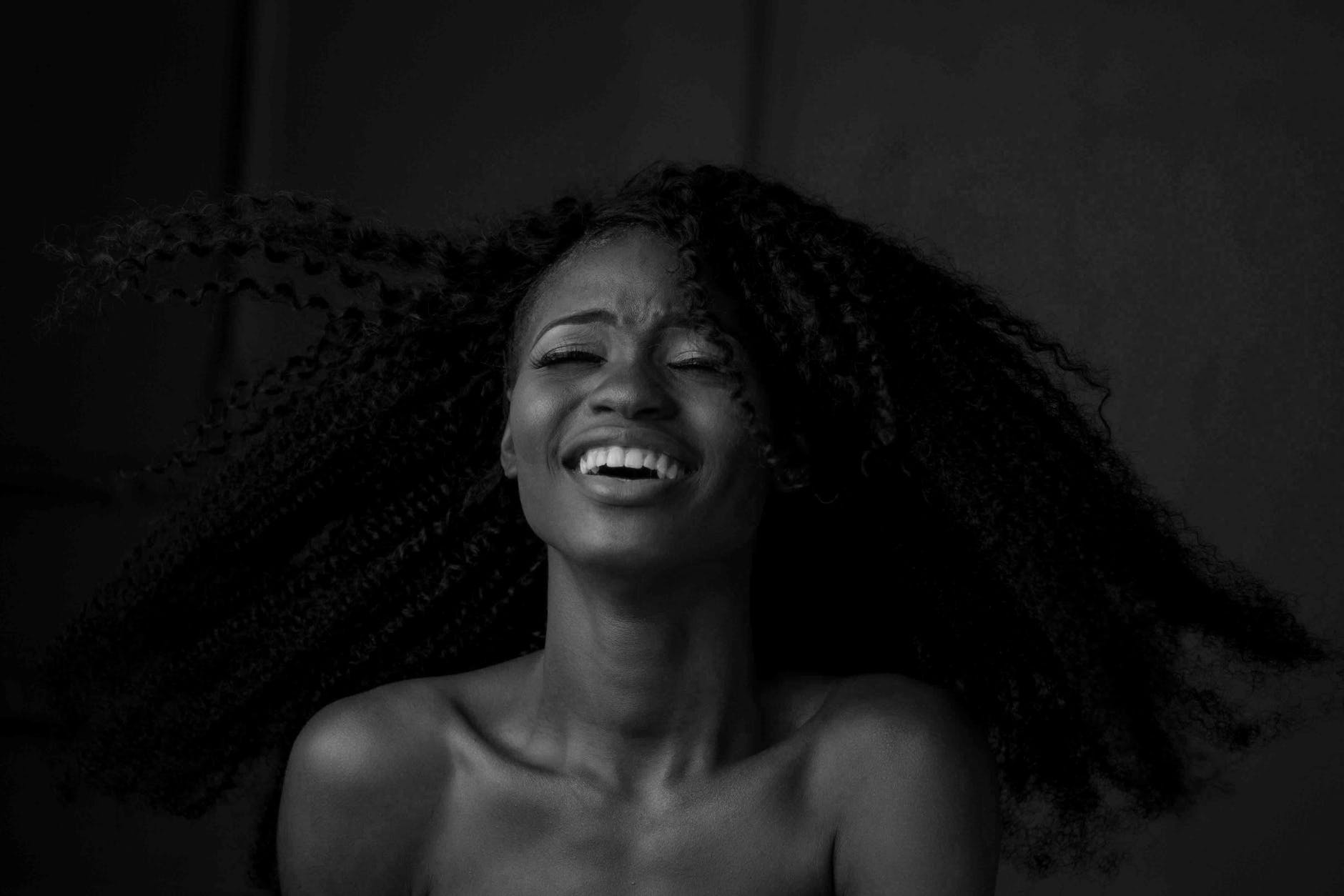 grayscale photography of smiling woman - benefits of laughing