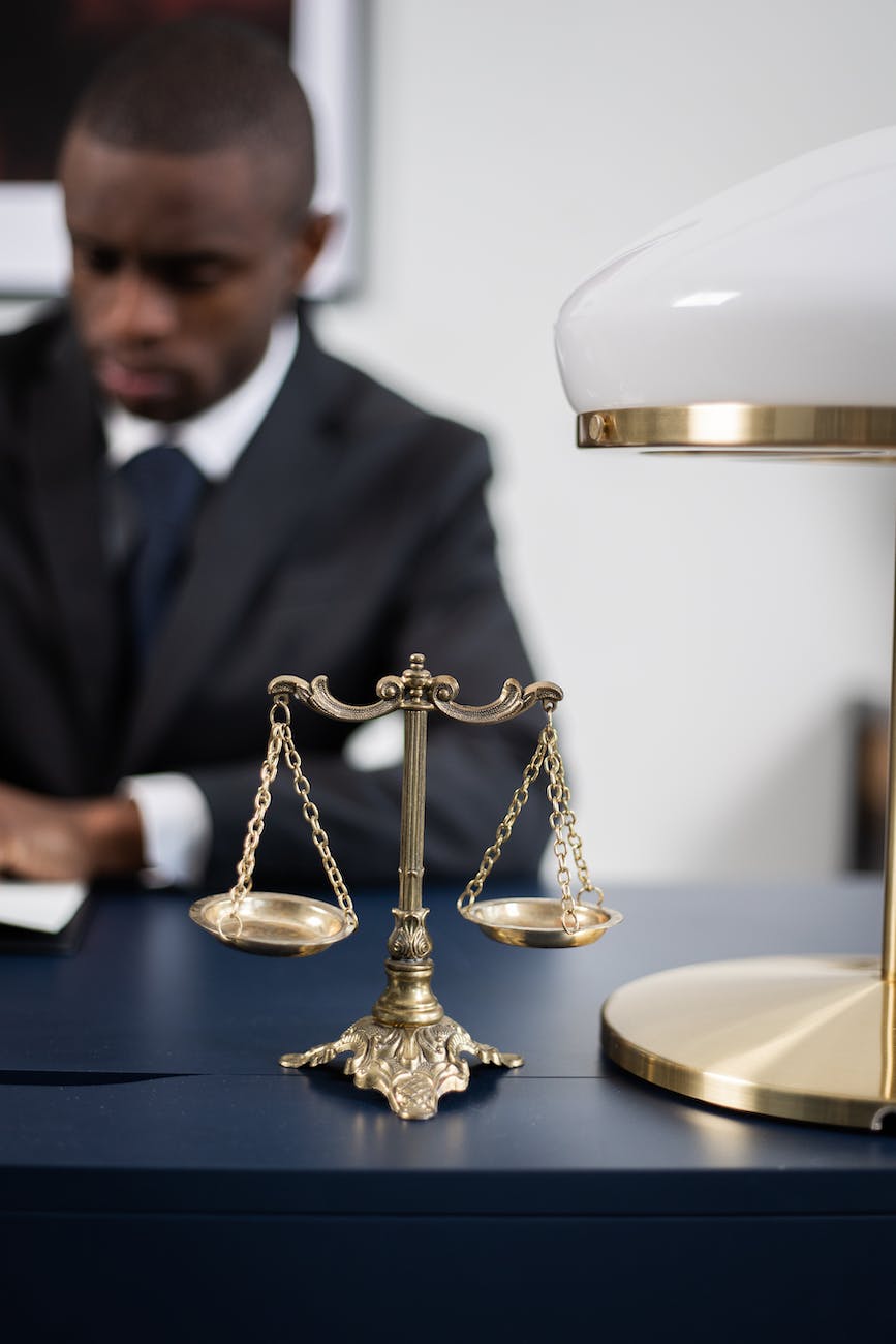 brass colored balance scale on a lawyer s table